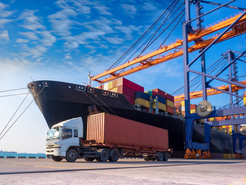 The container vessel during discharging at an industrial port and move containers to container yard by trucks