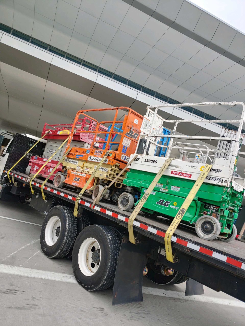 flatbed truck hauling construction equipment through NYC